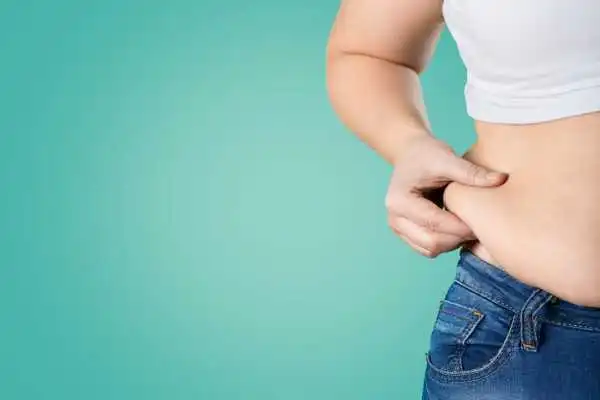 Image of woman pinching her love handles to show weight gain Basildon